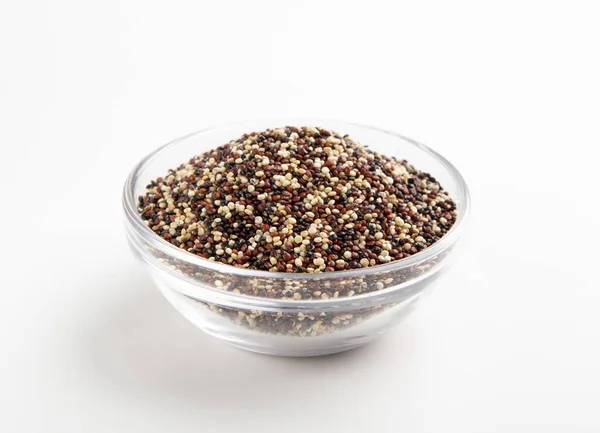 Meng van quinoa zaden in glazen schaal, witte achtergrond — Stockfoto