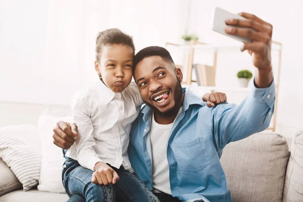 Feliz afro padre tomando selfie con su divertido hija — Foto de Stock