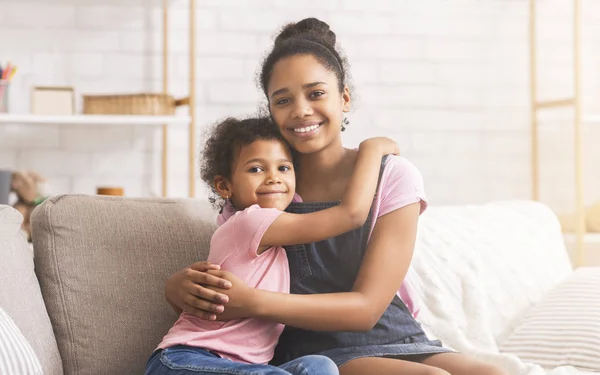 Hermanas afroamericanas felices abrazándose en casa —  Fotos de Stock