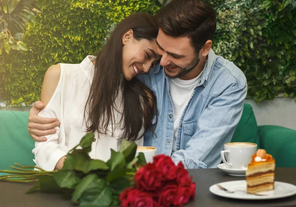Прекрасная пара обнимается с романтическим свиданием, сидя в кафе — стоковое фото