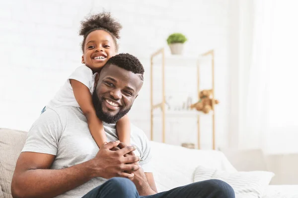 Lovely black daughter hugging young dad, home interior — Stok Foto