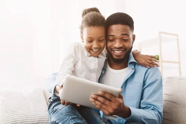 Tiempo en familia. Joven padre enseñando a su hija a usar tableta digital — Foto de Stock