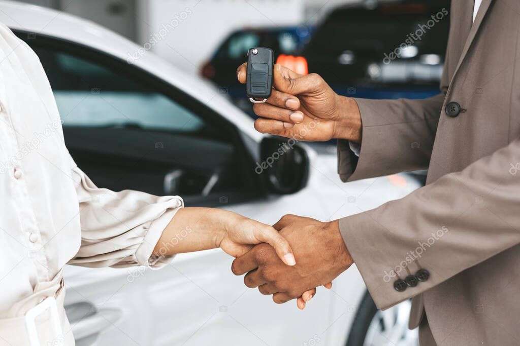 Seller Greeting Lady With Handshake Giving Car Key In Dealership
