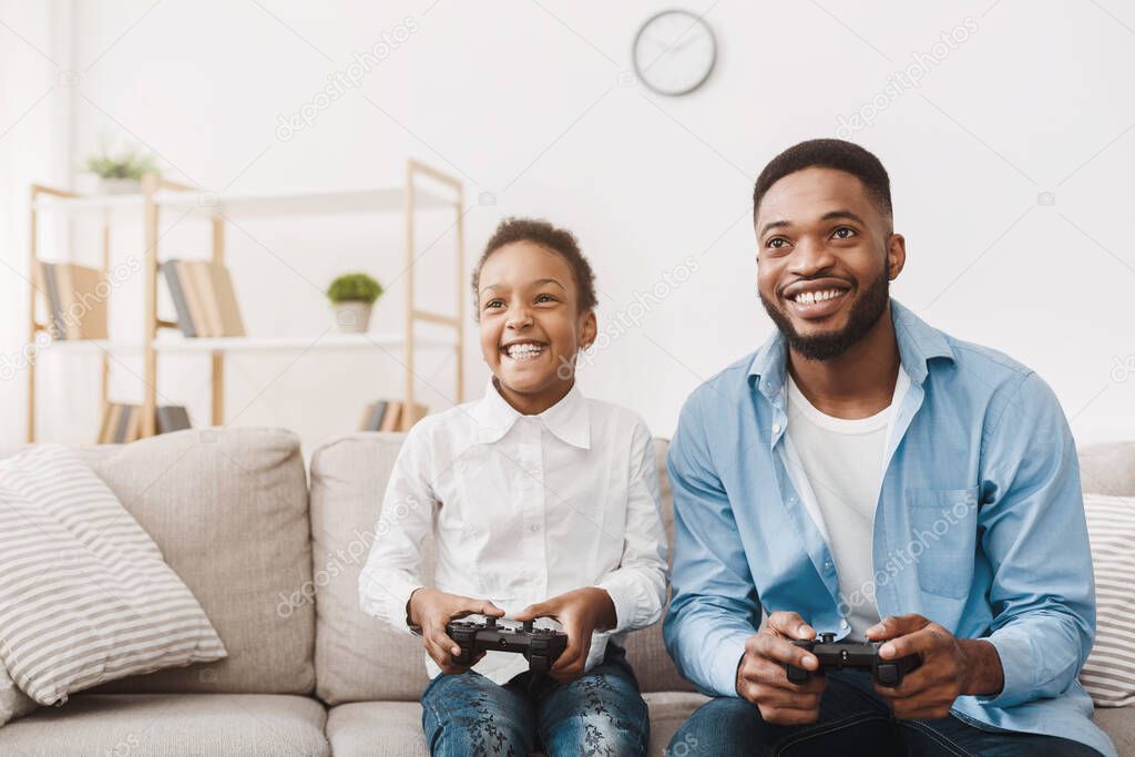 Happy afro dad enjoying video game with his cute daughter