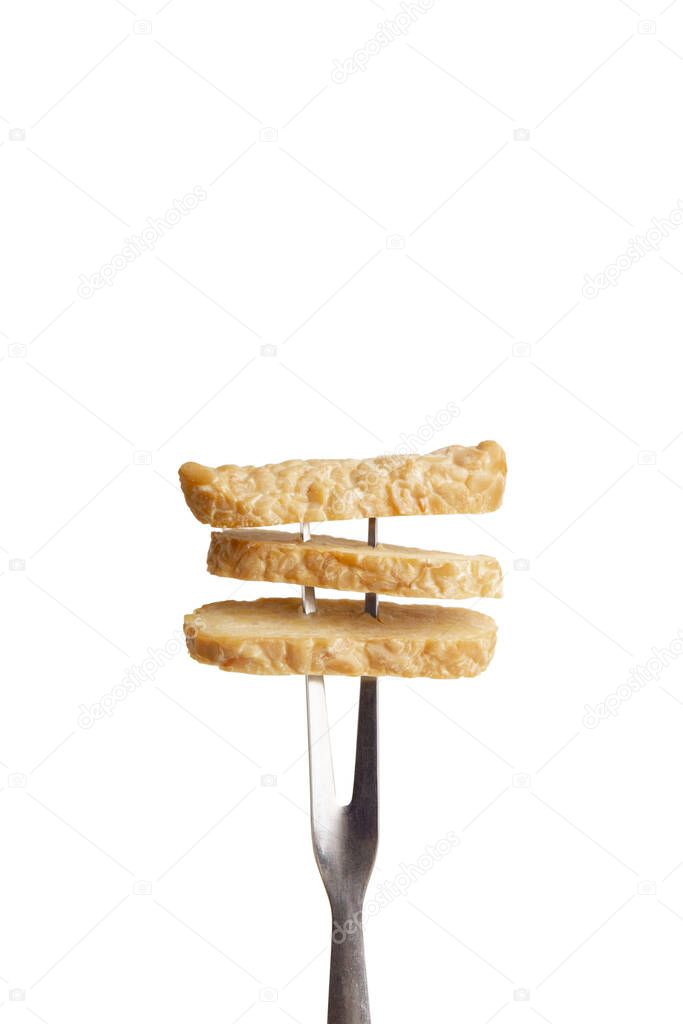 Tasty soybean appetizer Tempeh on fork, isolated