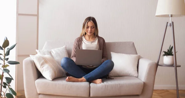 Giovane donna che chatta con un amico sul computer portatile a casa — Foto Stock