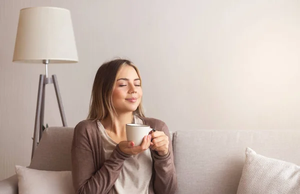 Millennial vrouw genieten van de geur van verse koffie thuis — Stockfoto