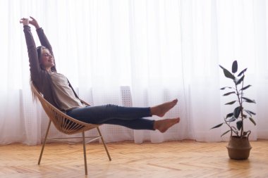 Mutlu kız vücudunu esnetiyor, evinin penceresinin yanında dinleniyor.