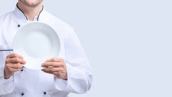 Chef irreconocible sosteniendo la placa sobre fondo de estudio blanco, Panorama — Foto de Stock
