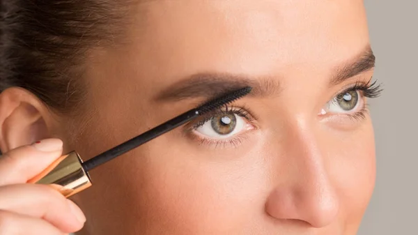 Mujer peinando sus cejas con cepillo de frente — Foto de Stock