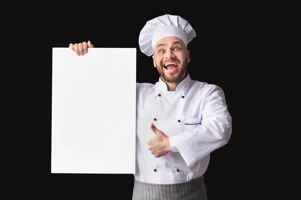 Kuchař drží prázdný plakát gesto palec nahoru na černém pozadí, posměch — Stock fotografie