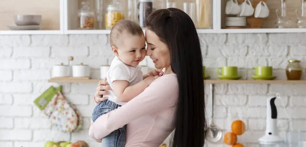 Baby und seine Mama umarmen sich in der Küche, panorama — Stockfoto