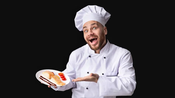 Chef macho excitado sirviendo filete de salmón de pie en el estudio, Panorama —  Fotos de Stock