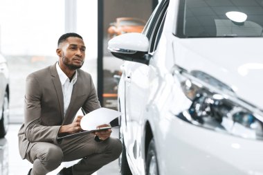 Sigorta acentesi, satış mağazasından araba notlarını kontrol ediyor.