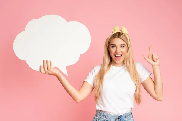 Portrait of girl holding speech bubble at pink studio — Stock Photo, Image