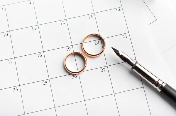 Χρυσές βέρες στο ημερολόγιο που συμβολίζουν την ημερομηνία του γάμου — Φωτογραφία Αρχείου