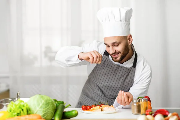 Chef macho condimento asado filete de salmón en la cocina — Foto de Stock