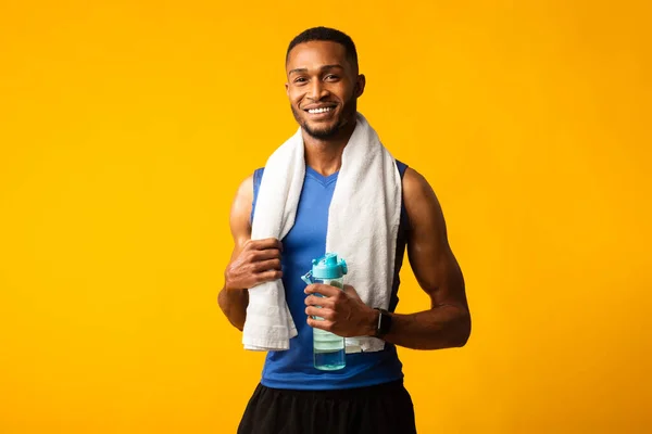 Elinde bir şişe su tutan sağlıklı bir afro adam. — Stok fotoğraf