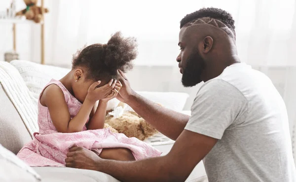 Africano pai reconfortante pouco chorando menina em casa — Fotografia de Stock