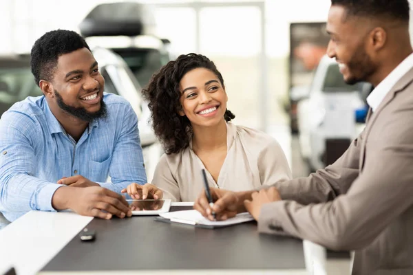 Couple Buying Car Signing Papers With Salesman In Dealership Office — Stock Photo, Image