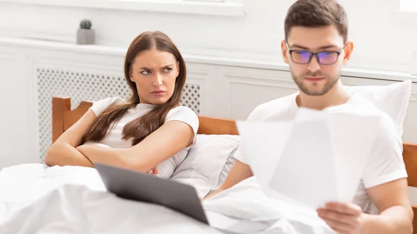 Busy Freelancer Working Lying With Angry Girlfriend In Bed, Panorama — Stock Photo, Image