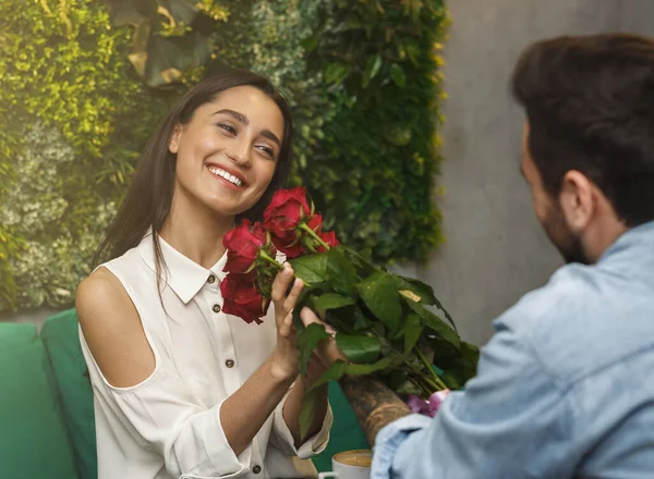 Ragazza prendendo mazzo da fidanzato avendo romantico data in caffetteria — Foto Stock