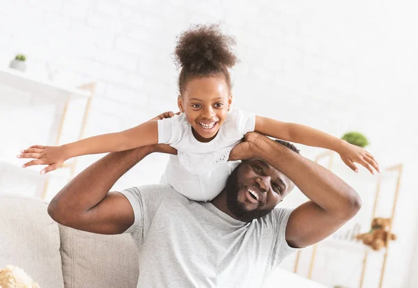 Afro family in white having fun at home