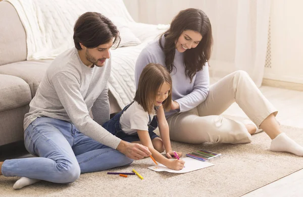 어린 딸 과 함께 집 바닥에 앉아 그림을 그리는 천년기 부모들 — 스톡 사진