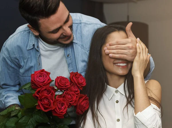 Novio dando a novia rosas cubriendo sus ojos en la cafetería — Foto de Stock