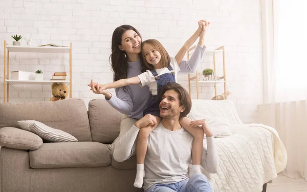 Jovem família alegre de três enganando juntos em casa, se divertindo — Fotografia de Stock