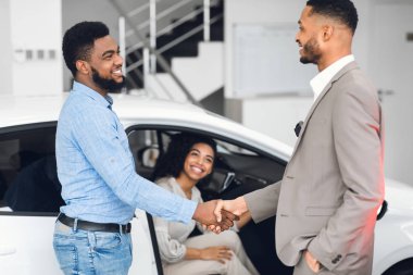 Satış müdürüyle el sıkışan adam galeride.