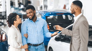 Satıcı, Otomobil Merkezinde Bekleyen Mutlu Müşterilere Anahtarı Veriyor