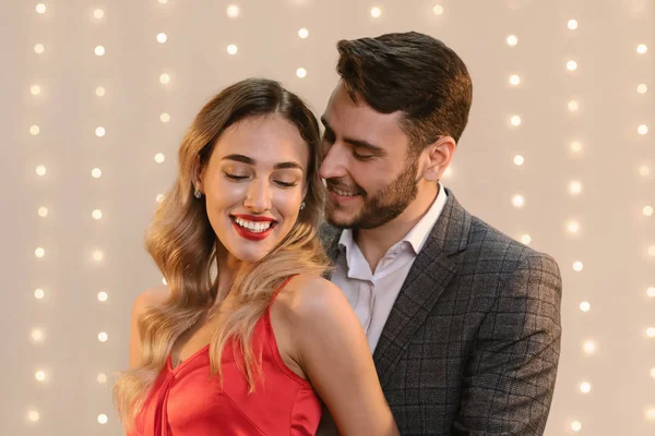 Casal elegante ligação e abraçando juntos sobre fundo bege — Fotografia de Stock