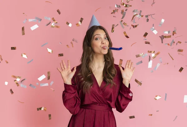 Doğum günü şapkası ve parti düdüğüyle konfeti altında duran heyecanlı kız — Stok fotoğraf