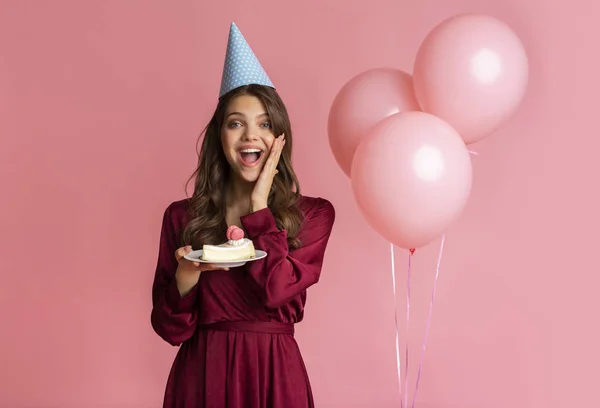 Surpris fille célébrer anniversaire et garder morceau de gâteau dans les mains — Photo