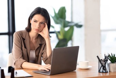 Avrupalı genç yönetici bilgisayar kullanarak başka tarafa bakıyor