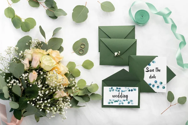 Svatební kytice a svatební pozvánky ve stylových tmavozelených obálkách — Stock fotografie