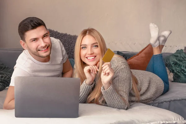 Feliz pareja sonriente utilizando el ordenador portátil en el dormitorio —  Fotos de Stock