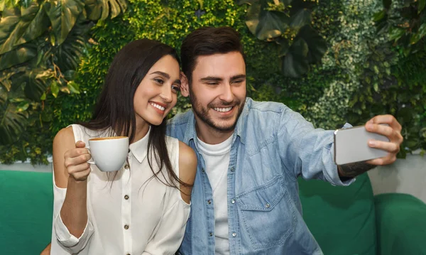 Vidám pár, akik Selfie ölelkeznek és kávéznak a kávézóban. — Stock Fotó