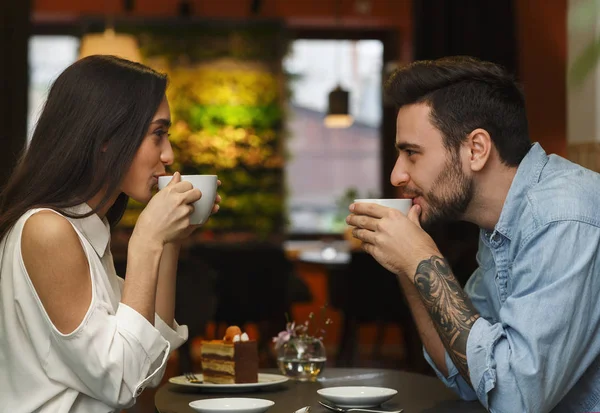 Para po kawie siedzi w przytulnej kawiarni, widok z boku — Zdjęcie stockowe