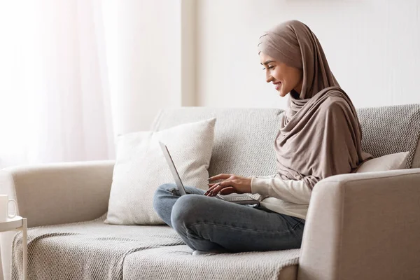 Mujer árabe joven freelancer en Hijab usando el ordenador portátil en casa — Foto de Stock
