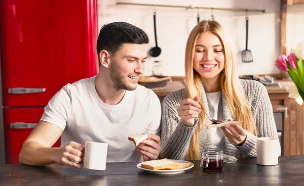 Young romantic couple is having breakfast on modern light kitchen — Stock Photo, Image