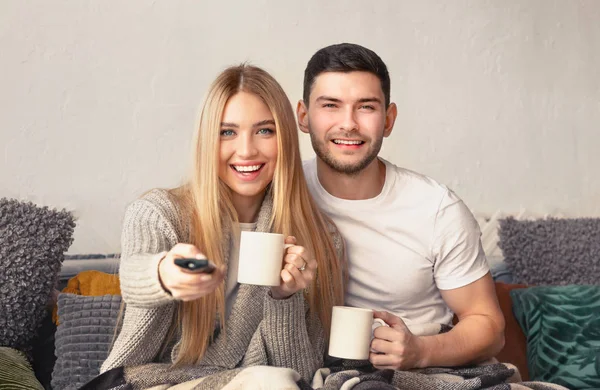 Alegre casal millennial beber chá e assistir TV — Fotografia de Stock