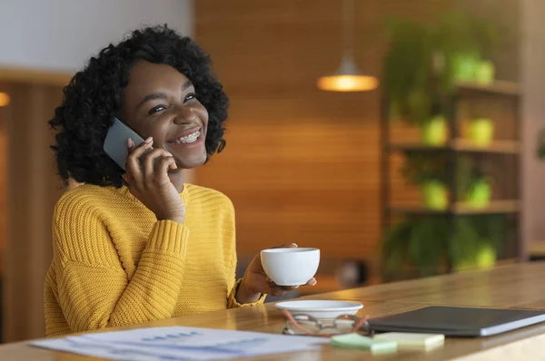 Jovem empresária negra feliz bebendo café no café, conversando — Fotografia de Stock