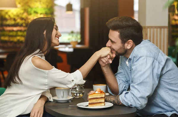 Kochający chłopak całujący dziewczyny ręka mając randkę w kawiarni — Zdjęcie stockowe