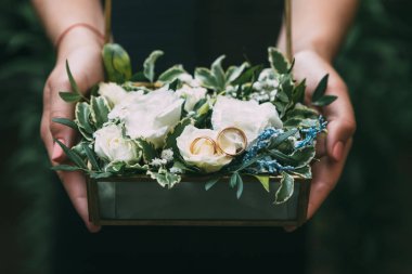 Bridesmaid preparing wedding rings on flowers pillow