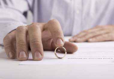 Woman signing divorce decree and taking off wedding ring