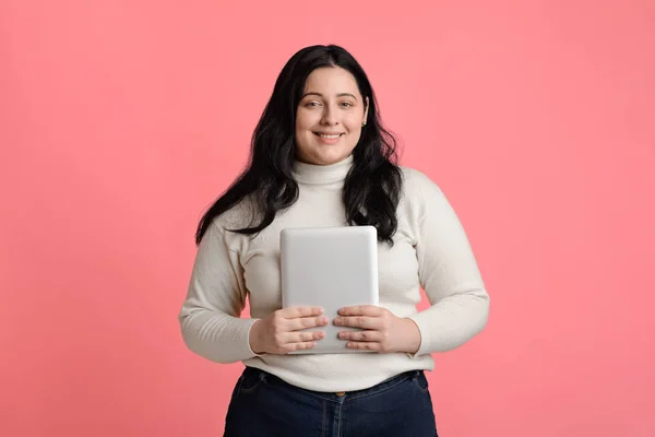 Glimlachen plus grootte meisje poseren met digitale tablet in handen — Stockfoto