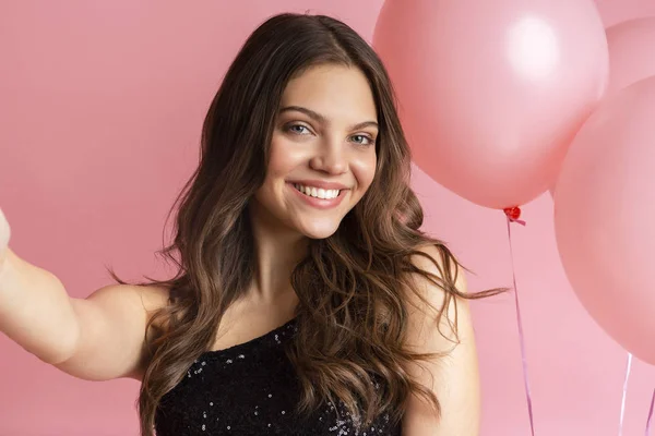 Jeune jolie femme prenant selfie avec de gros ballons roses sur fond . — Photo