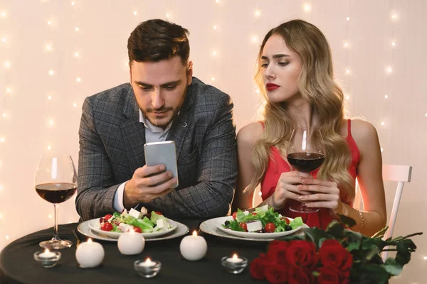 Jealous Woman Pekking Into Boyfriends Smartphone During Dinner In Restaurant — Stock Photo, Image